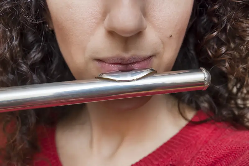 Closeup of woman playing flute - blowing