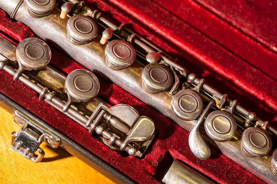 Tarnished old brass flute in velvet case close-up of keys