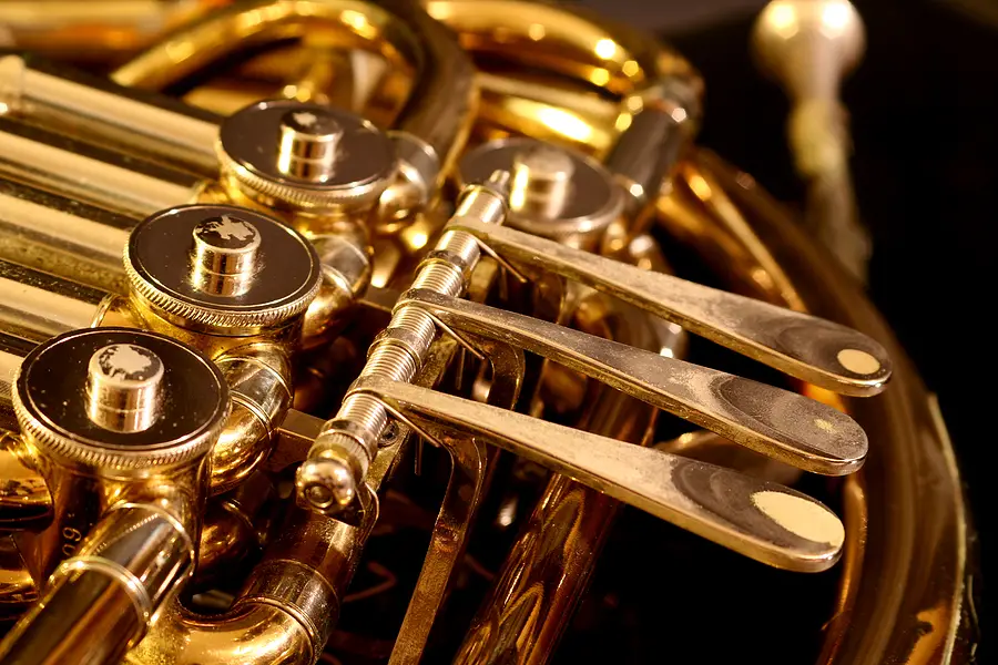 close up of brass french horn on black
